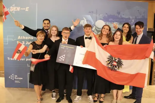 Österreichisches Team jubelt mit rot-weiß-roter Fahne vor der GEN-E-Fotowand