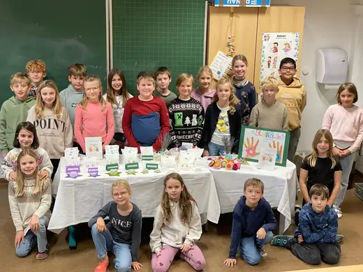 Volksschulklasse mit ihren selbst gemachten Produkten am Verkaufstisch